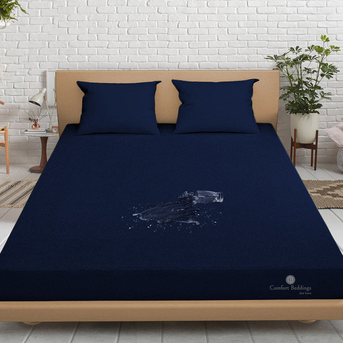 Navy blue waterproof terry mattress protector fitted on a bed